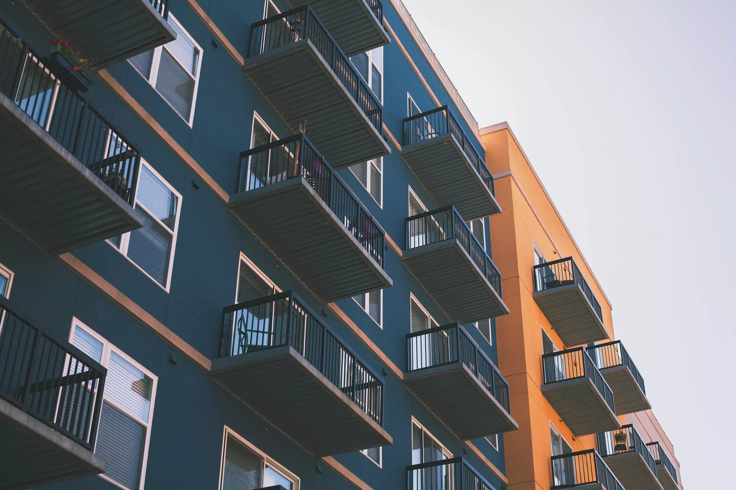 Balkonları sıralanan bir apartman cephesinin aşağıdan görünümü