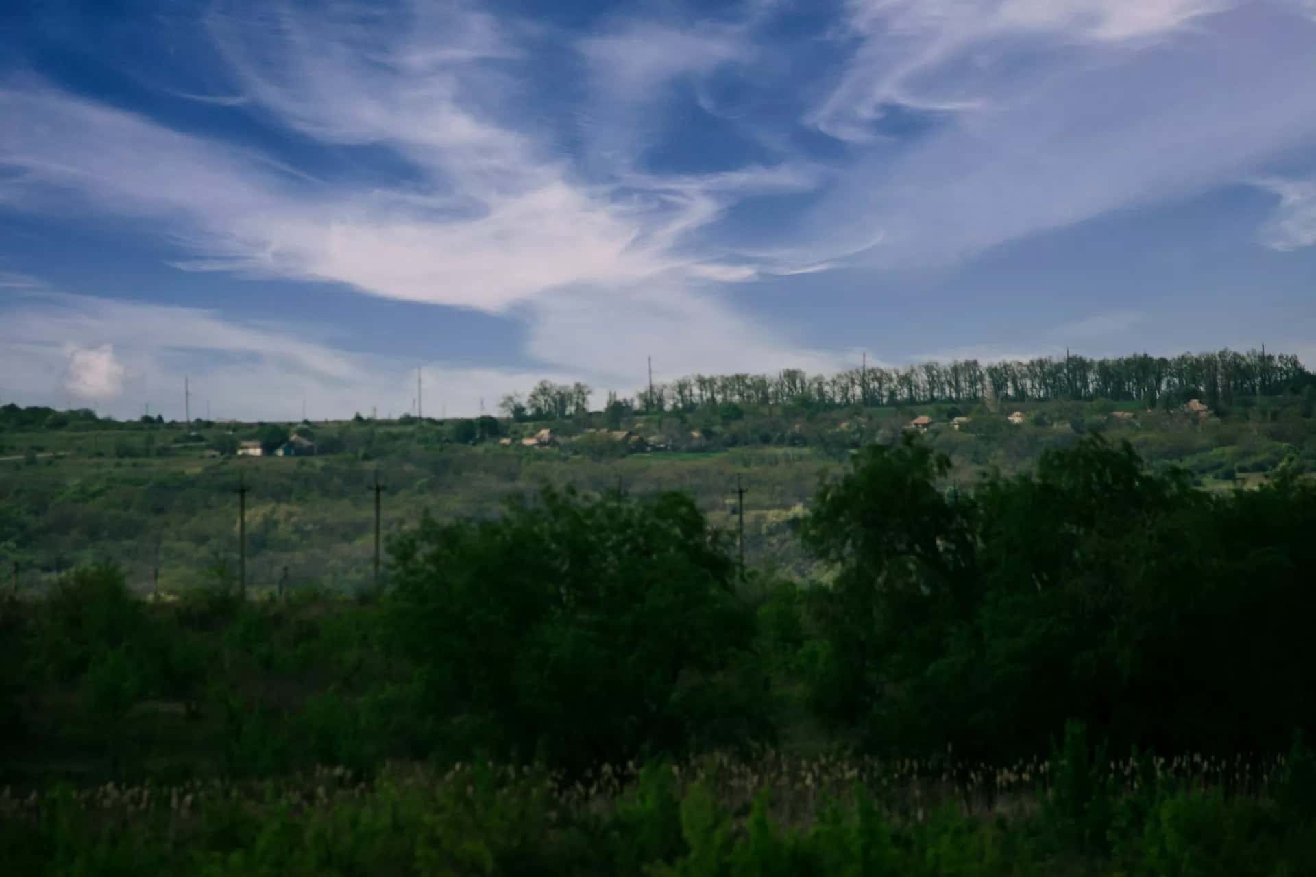 Uzak bir yamaçta seyrek dağılmış kır evleri