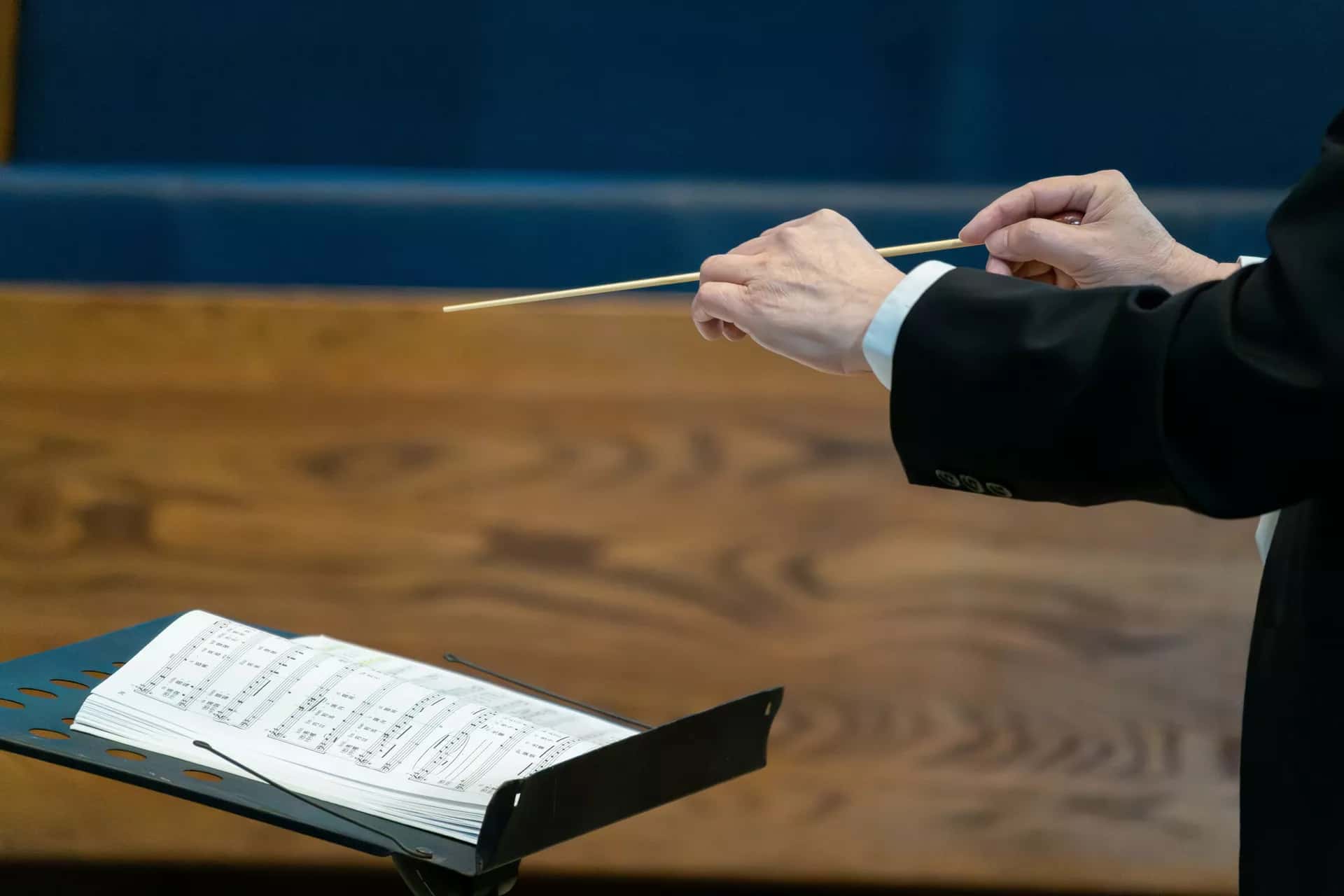 Nota kâğıtlarının üzerinde duran bir orkestra şefi batonu