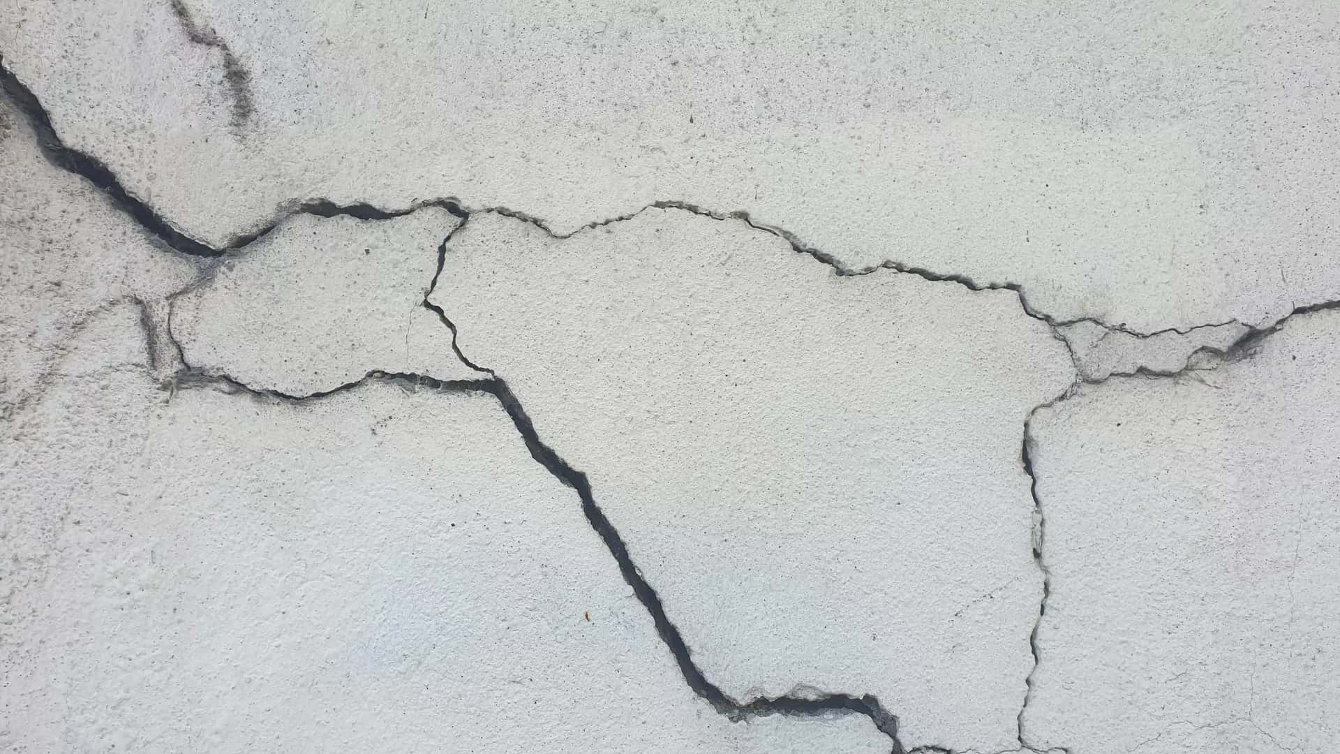 Eski bir binanın sıvası dökülmüş, çatlaklarla kaplı iç duvarı